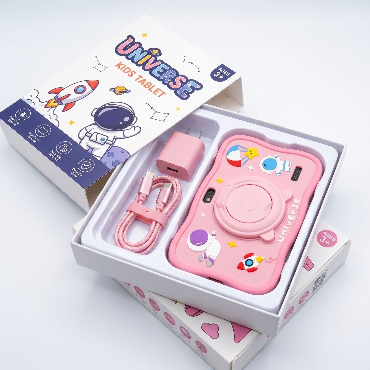 Embalagem do Universe Tablet Kids aberta com o tablet rosa, cabo USB e carregador